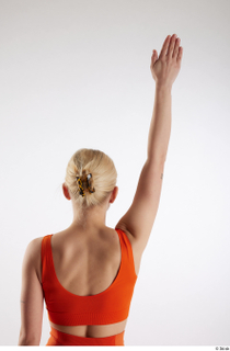 Unaisa  1 arm back view dressed flexing orange sports…
